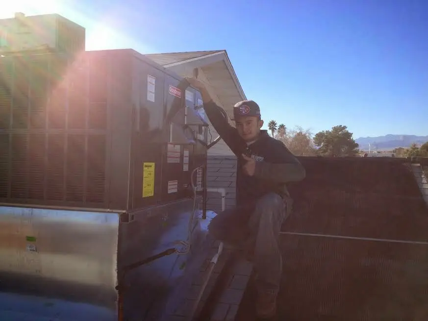 HVAC technician performing Air Duct Cleaning on a rooftop unit in Walkersville