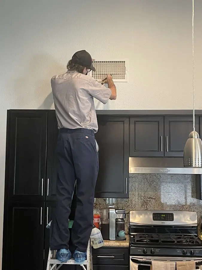 Technician inspecting an air vent during HVAC service in Walkersville